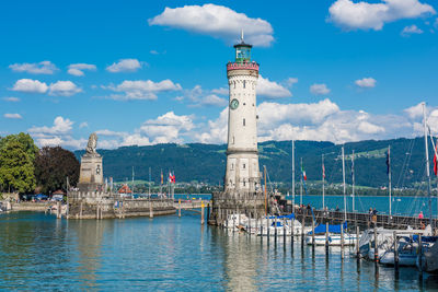 Lighthouse by sea against sky