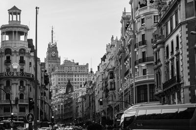 Cars on road amidst buildings in city against sky