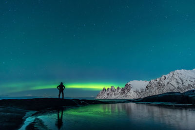 Man standing by sea against sky at night