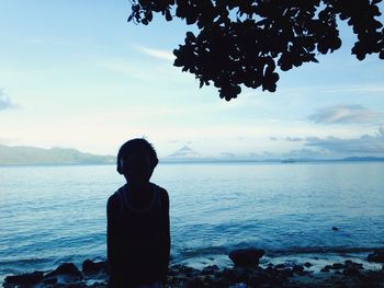 Rear view of man sitting on beach