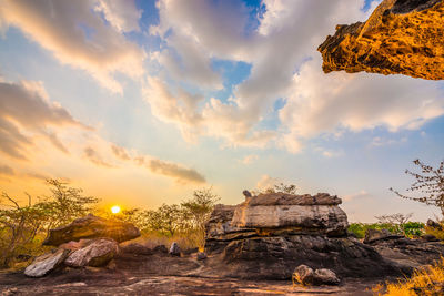 Rock formation on land against sky during sunset