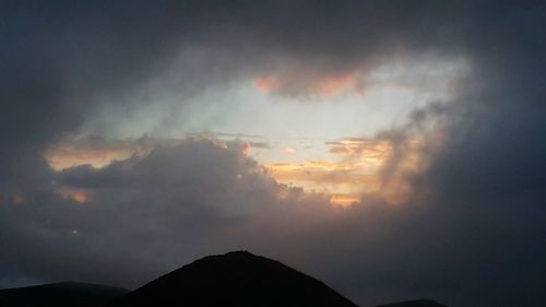 Scenic view of silhouette mountain against dramatic sky