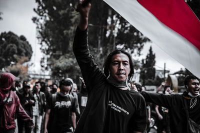 Portrait of young man standing in front of flags