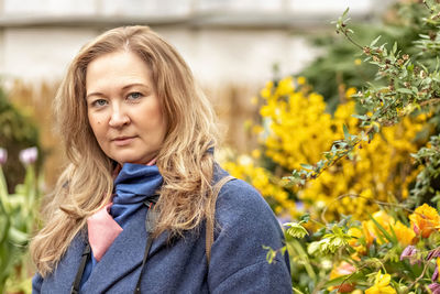 A middle-aged woman sniffs and admires tulips in the botanical garden.spring