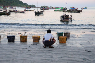 Rear view of people sitting on beach