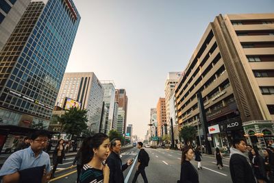 People on street in city against clear sky