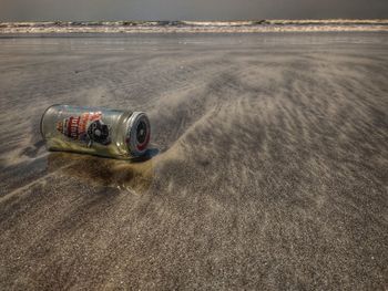 High angle view of sunglasses on sand at beach