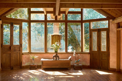 Interior of spacious meditation hall in house with potted plants and parquet in daytime