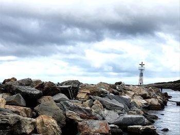Rocks by sea against sky