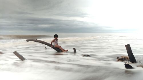 Man in sea against sky