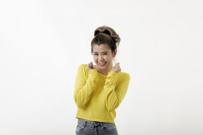 Portrait of smiling woman standing against white background