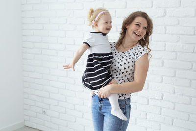 Young woman standing against wall