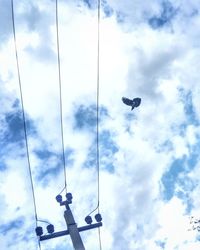 Low angle view of birds on street light against sky