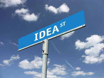 Low angle view of road sign against sky