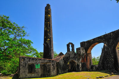 Low angle view of old ruins against clear blue sky
