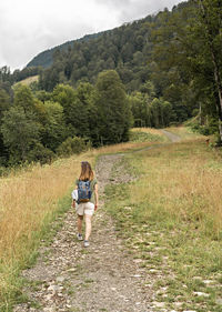 Rear view of man walking on road