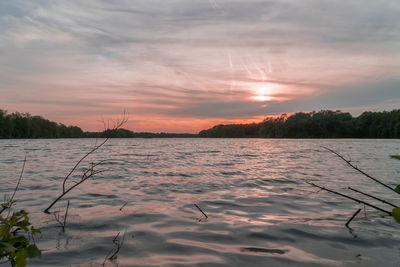 Scenic view of lake against sky at sunset