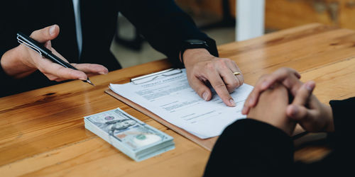 Midsection of business colleagues working on table