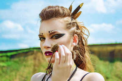 Portrait of beautiful young woman against sky