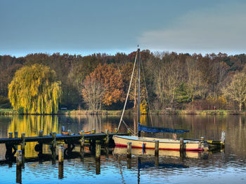 Boats moored in lake against sky