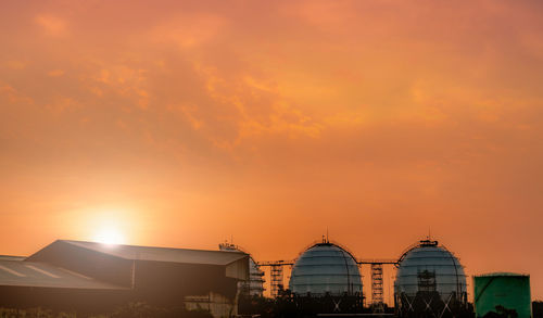 Industrial gas storage tank. lng or liquefied natural gas storage tank. red and orange sunset sky.
