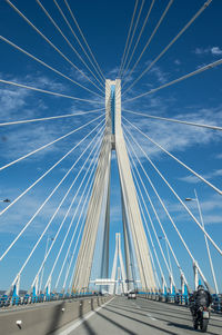 Low angle view of suspension bridge against blue sky