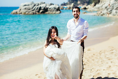 Portrait of happy couple standing on beach