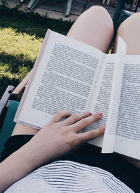 Low section of person reading book on paper