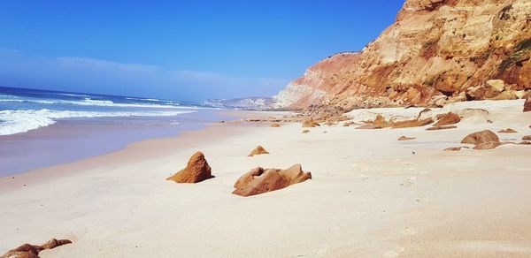 Rocks on beach against sky