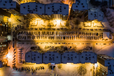 Drone view of illuminated buildings in city at night during winter