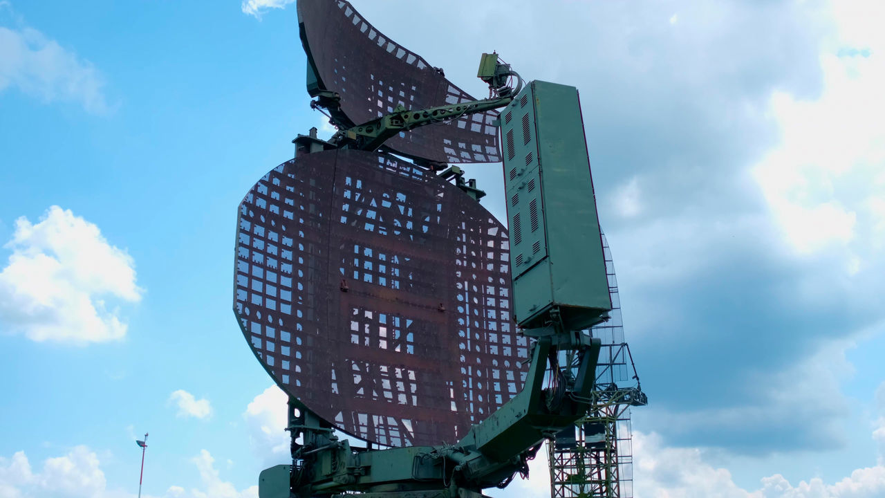 LOW ANGLE VIEW OF COMMUNICATIONS TOWER AGAINST CLOUDY SKY