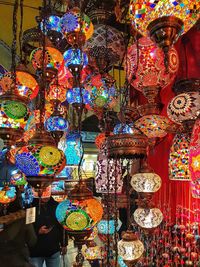 Illuminated lanterns hanging in market stall