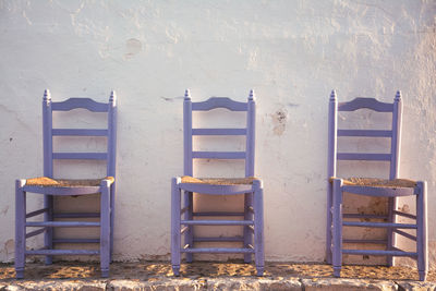 Empty chairs and tables against wall