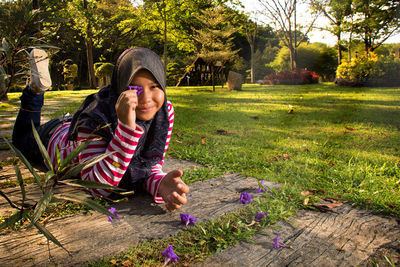 Portrait of a smiling young woman sitting on grassy field