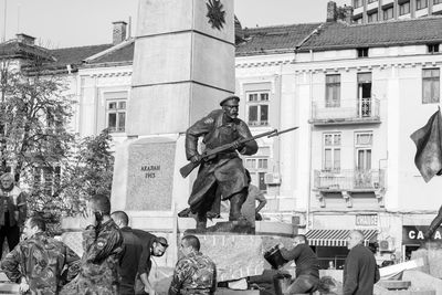 Statue against buildings in city