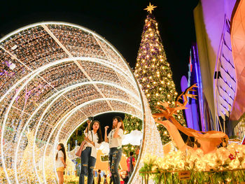 People in illuminated traditional building at night