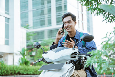 Side view of young man riding bicycle on road