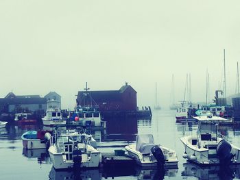 Boats in harbor against clear sky