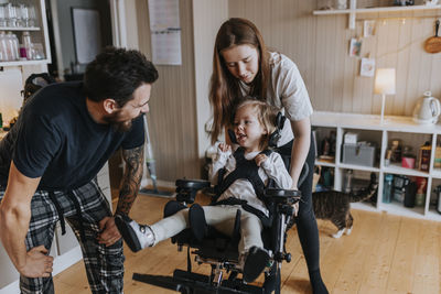 Parents with disabled child in wheelchair at home