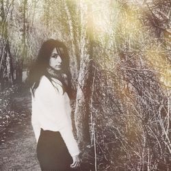 Woman standing on tree trunk