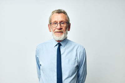 Portrait of young man standing against gray background