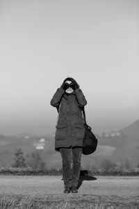 Man photographing on field against clear sky