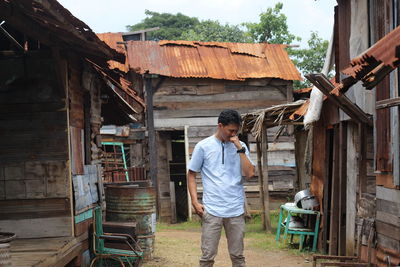 Man standing by wooden building