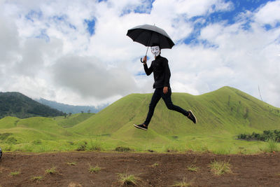 Man wearing mask while jumping on field