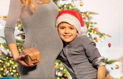 Portrait of smiling young woman holding gift box