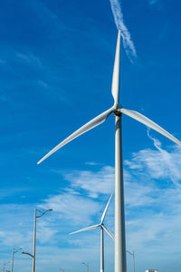 Low angle view of wind turbine against blue sky
