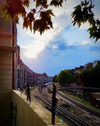 Railroad tracks by trees against sky