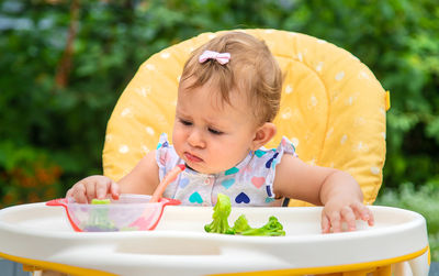 Cute girl looking at broccoli