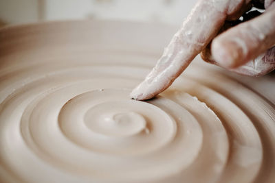 Decorating wet clay on potters wheel with a wine groove