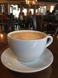 Close-up of cappuccino served on table at cafe